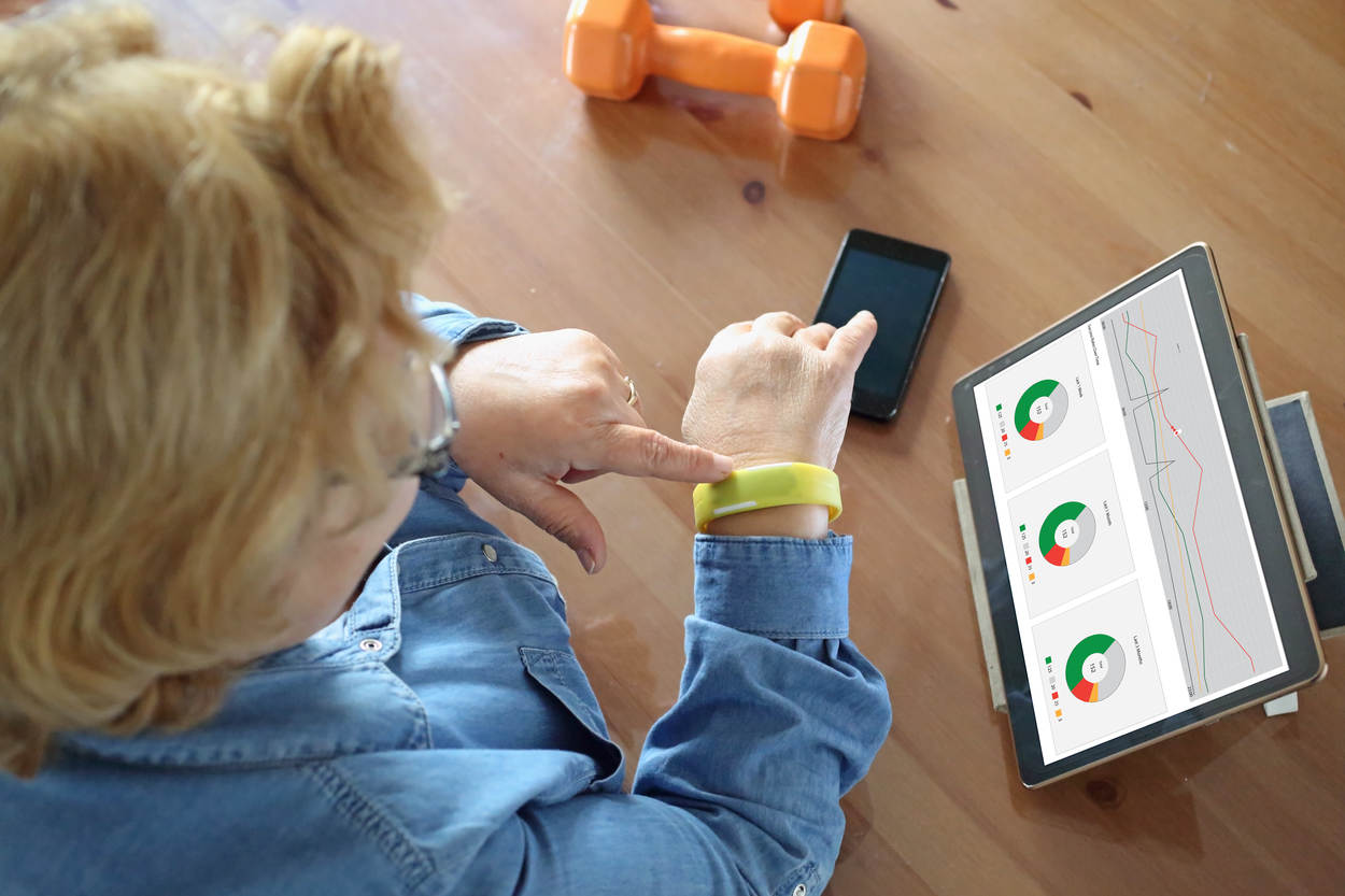 Dame maakt gebruik van medische armband en tablet